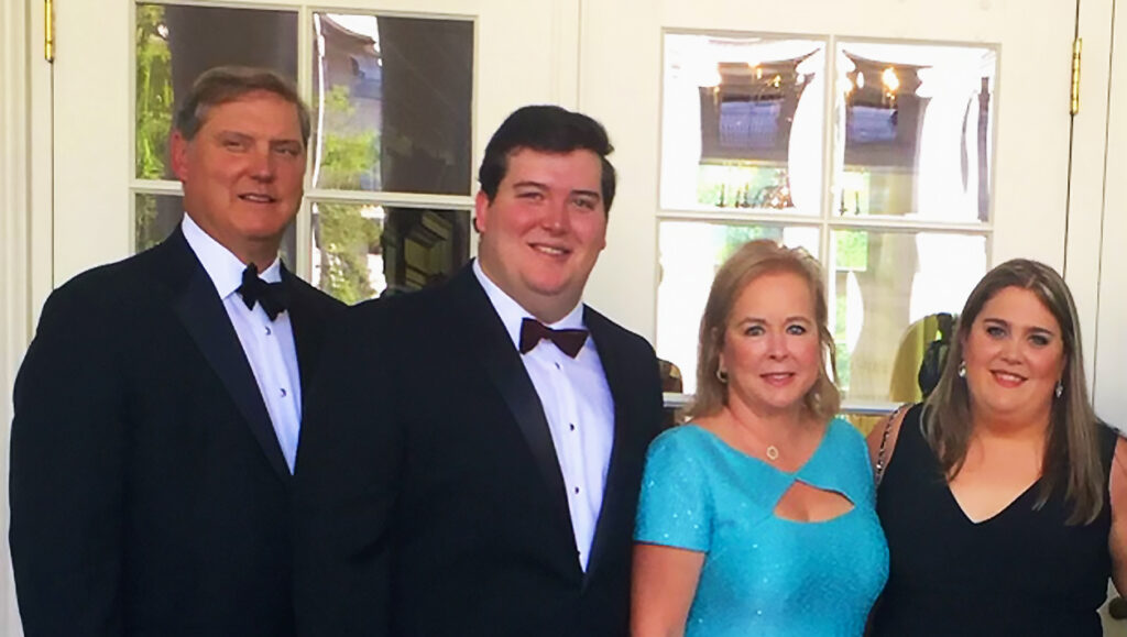 Photograph of two men and two women posing together in formalwear.